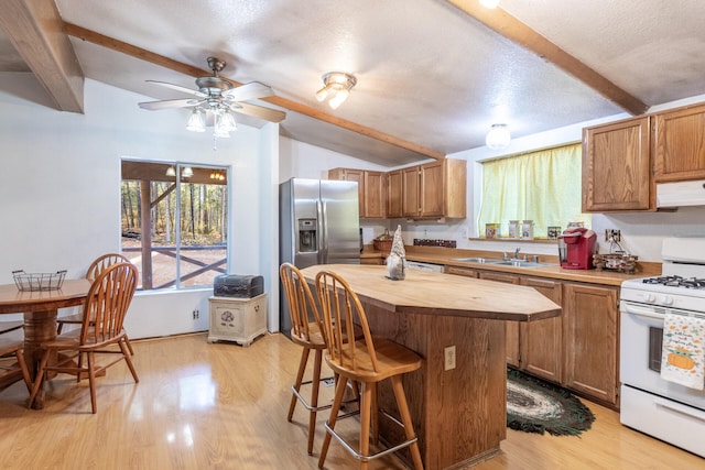 kitchen featuring a center island, vaulted ceiling with beams, range hood, white range with gas cooktop, and light wood-type flooring