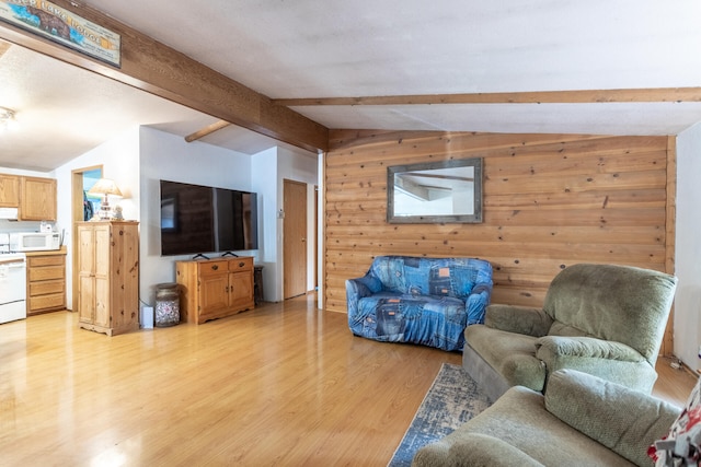 living room with vaulted ceiling with beams, wood walls, and light hardwood / wood-style flooring