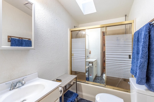 full bathroom with vanity, toilet, bath / shower combo with glass door, and a skylight