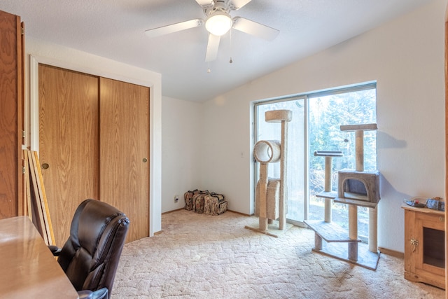 carpeted office space with ceiling fan and lofted ceiling