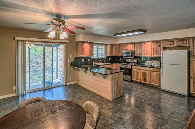 kitchen featuring tasteful backsplash, kitchen peninsula, plenty of natural light, and stainless steel appliances