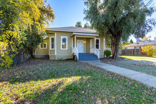 bungalow-style house with a front yard and cooling unit