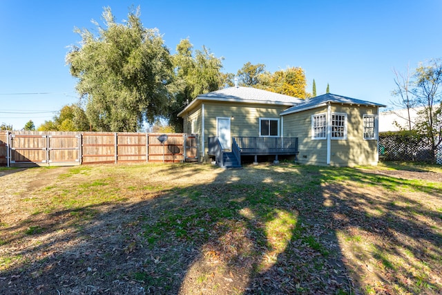 rear view of house featuring a yard and a deck