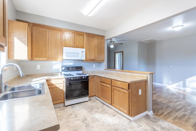 kitchen featuring ceiling fan, sink, light hardwood / wood-style flooring, kitchen peninsula, and white appliances