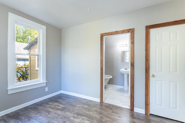 unfurnished bedroom featuring dark hardwood / wood-style floors and ensuite bathroom