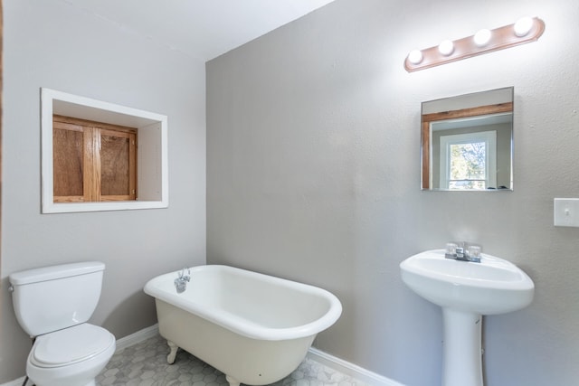 bathroom with a bathing tub, tile patterned flooring, toilet, and sink