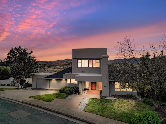 modern home featuring a mountain view, a yard, and a garage