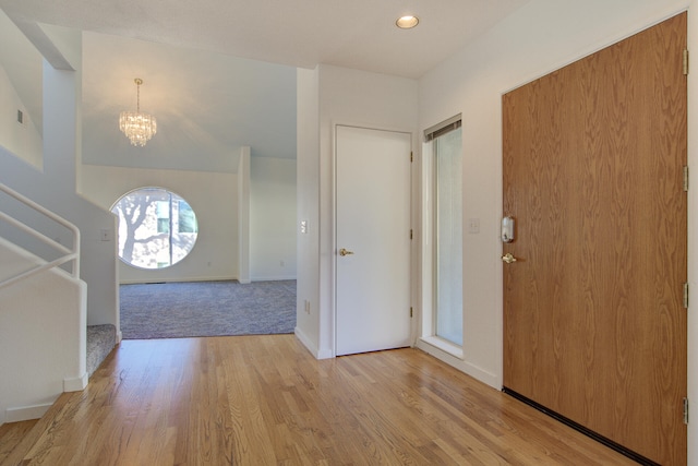 foyer entrance featuring light hardwood / wood-style flooring and an inviting chandelier