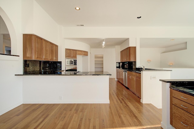 738 Sunriver Ln, Redding, CA 96001 - kitchen featuring a peninsula, appliances with stainless steel finishes, light wood finished floors, brown cabinets, and recessed lighting