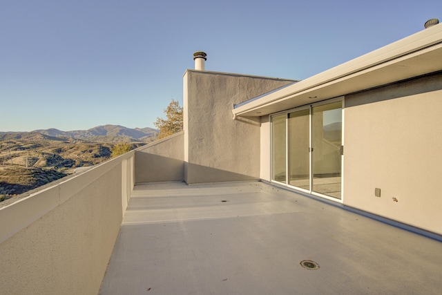 view of patio with a mountain view and a balcony