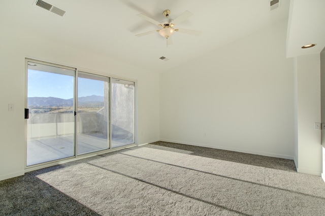 carpeted spare room featuring a mountain view and ceiling fan