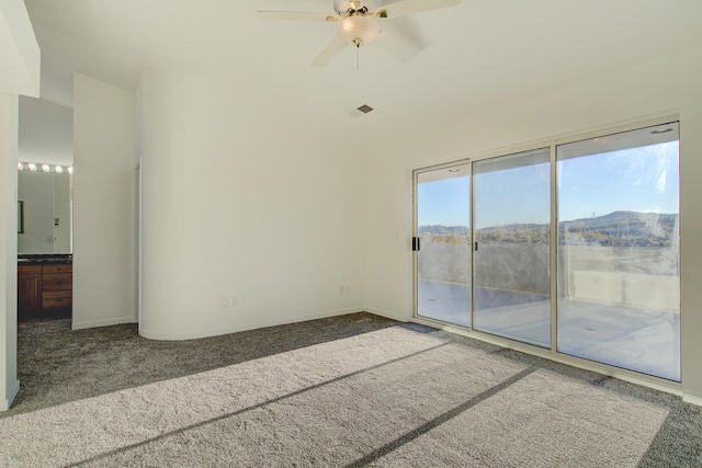 spare room with carpet flooring, a mountain view, and ceiling fan