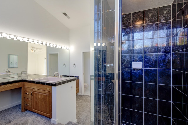 bathroom featuring vanity, toilet, a shower with shower door, and a textured ceiling