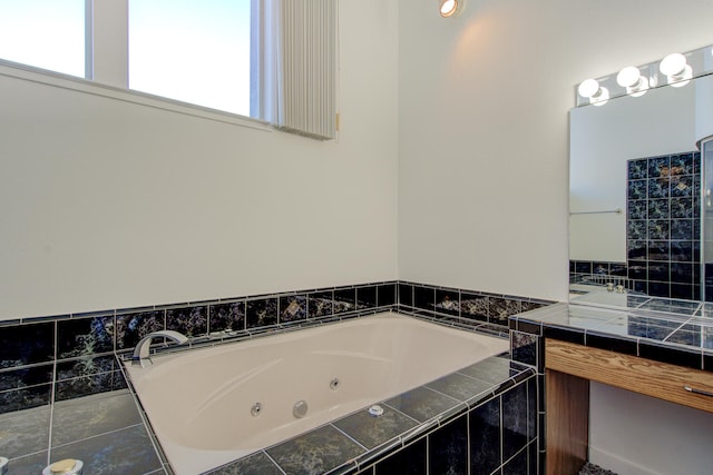 bathroom featuring tiled bath and vanity