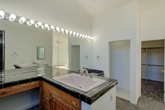 bathroom with vanity and high vaulted ceiling