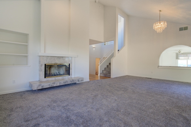 unfurnished living room featuring high vaulted ceiling, ceiling fan with notable chandelier, carpet flooring, built in features, and a fireplace