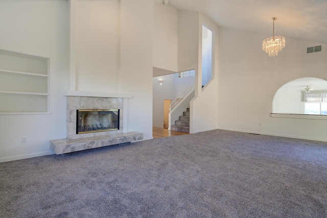 738 Sunriver Ln, Redding, CA 96001 - unfurnished living room featuring high vaulted ceiling, carpet flooring, a tiled fireplace, stairway, and a chandelier