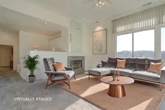 living room featuring a mountain view, light colored carpet, and ceiling fan