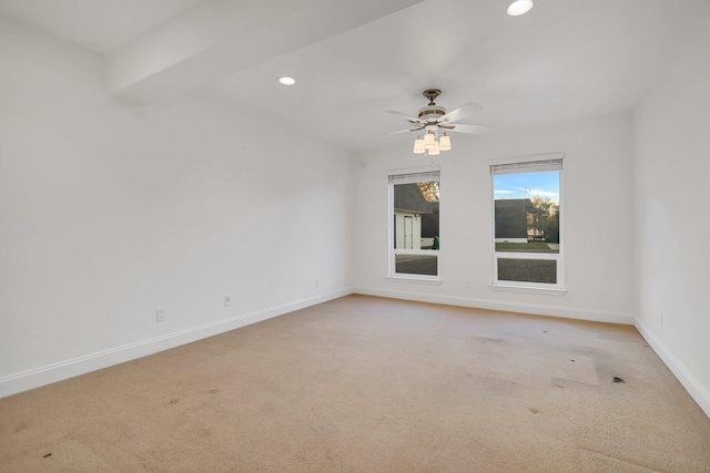 carpeted spare room with ceiling fan and beamed ceiling