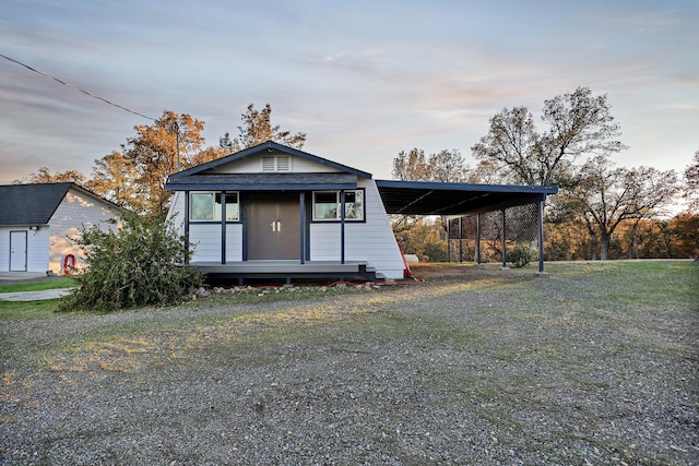 view of front facade featuring a carport and a lawn