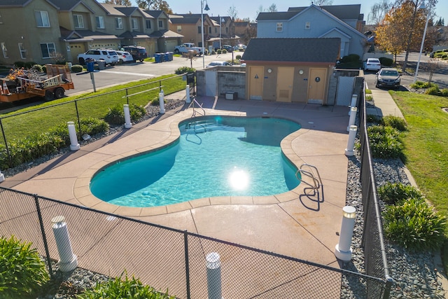 view of swimming pool featuring an outbuilding and a patio