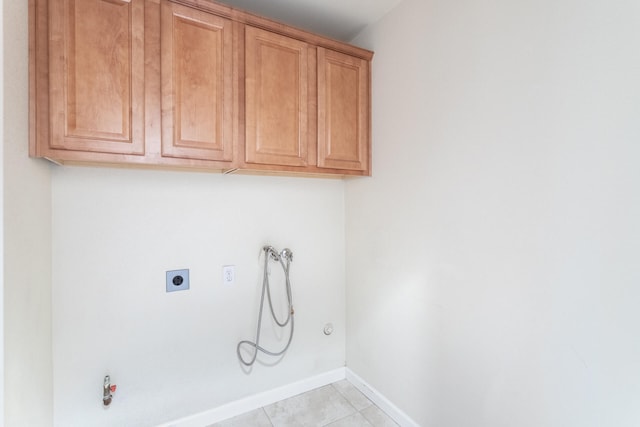 washroom with hookup for a gas dryer, hookup for a washing machine, light tile patterned floors, and cabinets