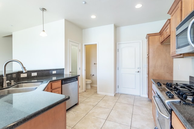 kitchen with pendant lighting, sink, light tile patterned floors, and stainless steel appliances