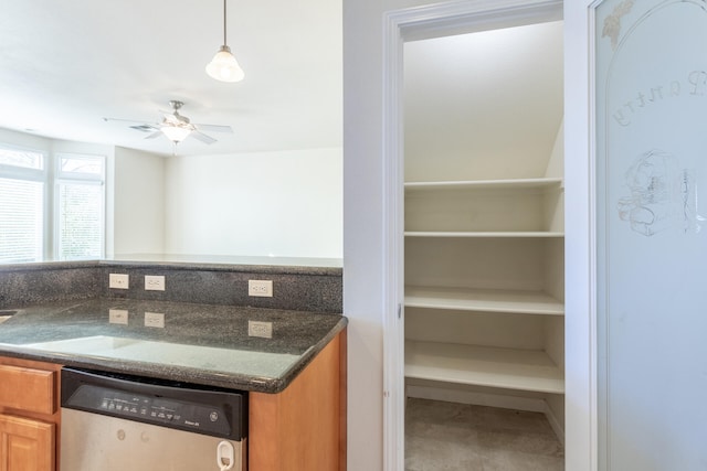 kitchen featuring dishwasher, ceiling fan, dark stone countertops, and hanging light fixtures