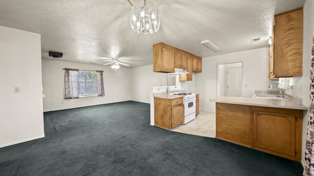 kitchen with white gas range, a textured ceiling, a sink, light countertops, and light carpet