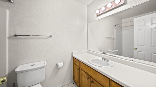 full bath with vanity, baseboards, toilet, and a shower