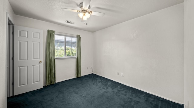unfurnished room featuring visible vents, baseboards, dark colored carpet, a textured ceiling, and a ceiling fan