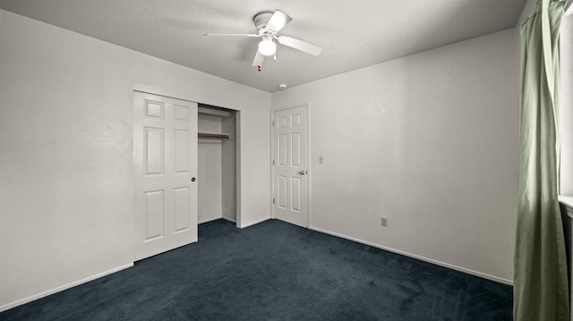 unfurnished bedroom with dark carpet, a ceiling fan, baseboards, and a closet