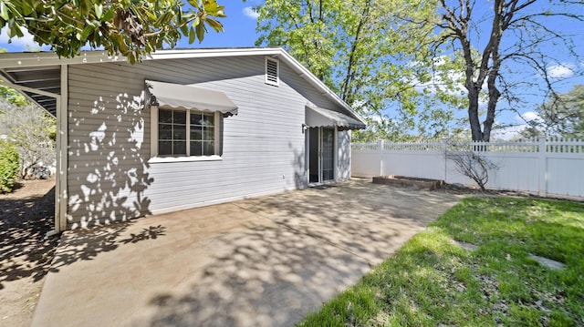 rear view of house with a patio and fence