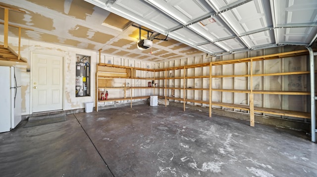 garage featuring gas water heater, a garage door opener, and freestanding refrigerator