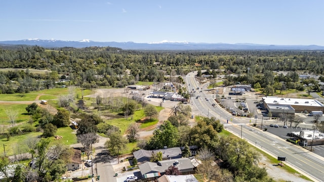 birds eye view of property featuring a wooded view and a mountain view