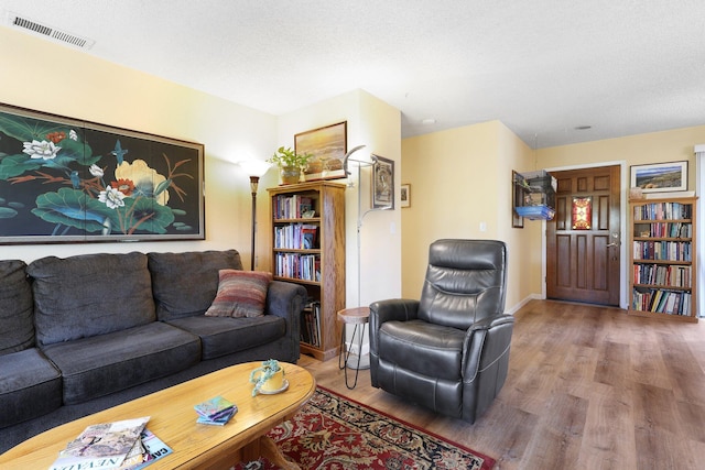 living room featuring hardwood / wood-style floors and a textured ceiling