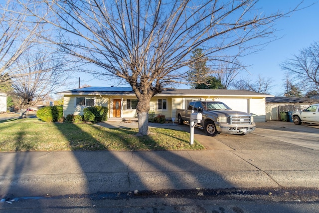 single story home with a front yard and solar panels