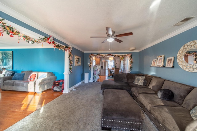 living room with a textured ceiling, hardwood / wood-style flooring, ceiling fan, and crown molding