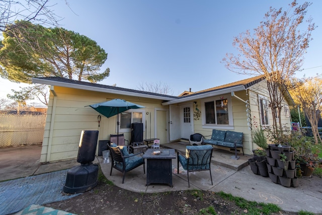 back of house featuring an outdoor living space with a fire pit and a patio area