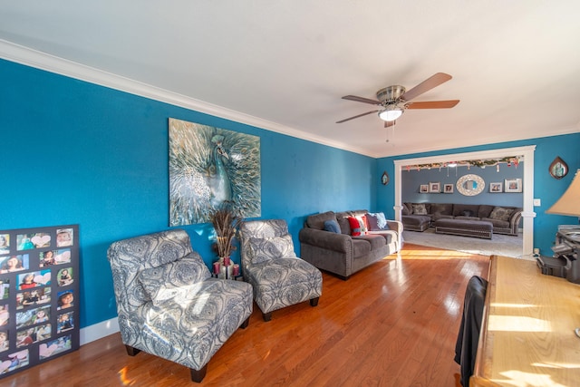 living room with ceiling fan, wood-type flooring, and crown molding