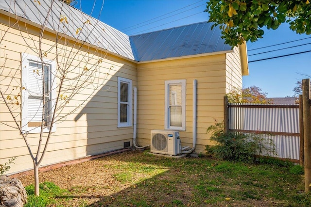 view of side of property with ac unit and a yard