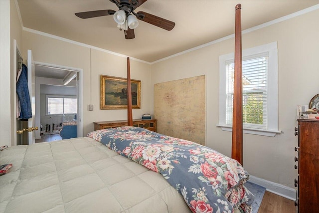 bedroom featuring hardwood / wood-style floors, ceiling fan, and crown molding