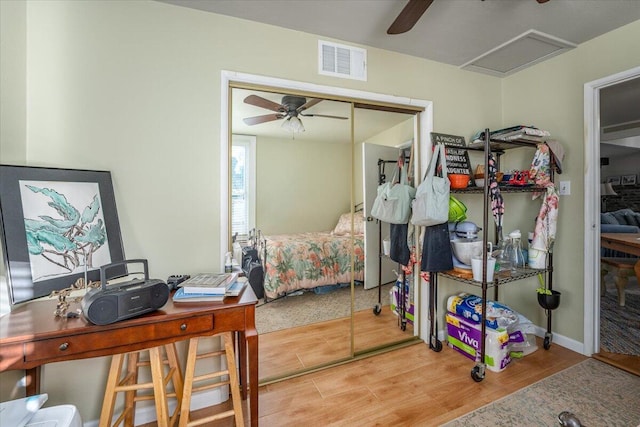 bedroom with light hardwood / wood-style flooring, a closet, and ceiling fan