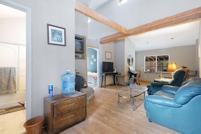 living room featuring lofted ceiling with beams and light wood-type flooring