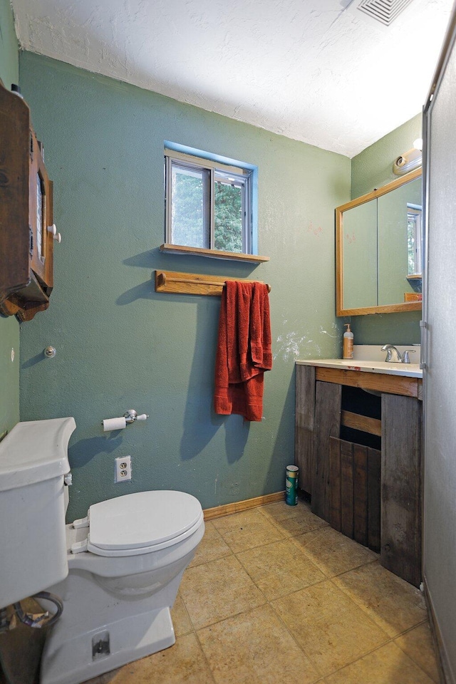 bathroom featuring tile patterned flooring, vanity, and toilet