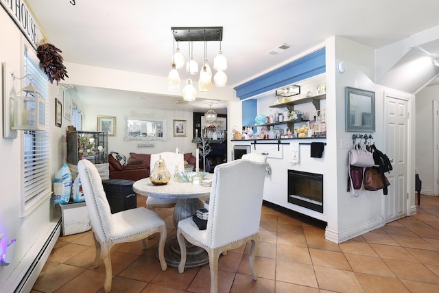 tiled dining space with a chandelier and a baseboard radiator