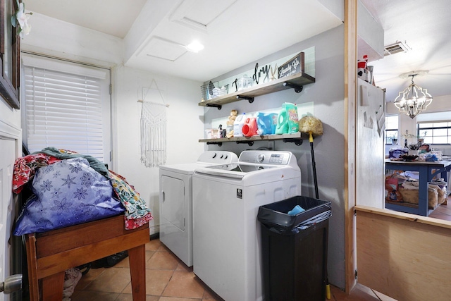 washroom featuring independent washer and dryer, a notable chandelier, and light tile patterned flooring