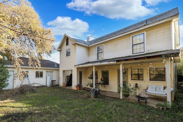 back of house featuring a lawn and a patio