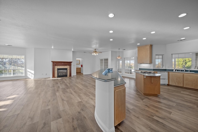 kitchen with light hardwood / wood-style flooring, a kitchen island, white dishwasher, and sink