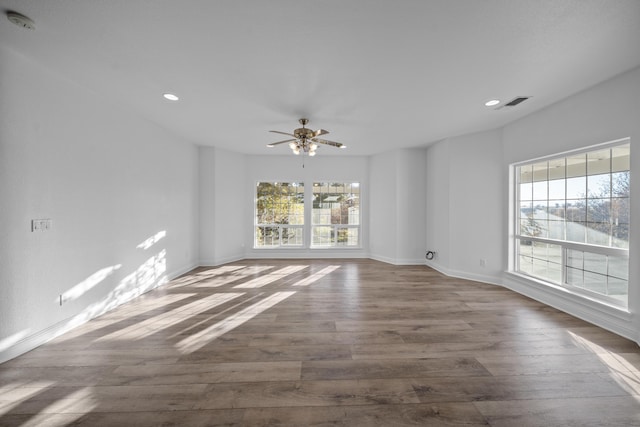 empty room with hardwood / wood-style flooring, a wealth of natural light, and ceiling fan